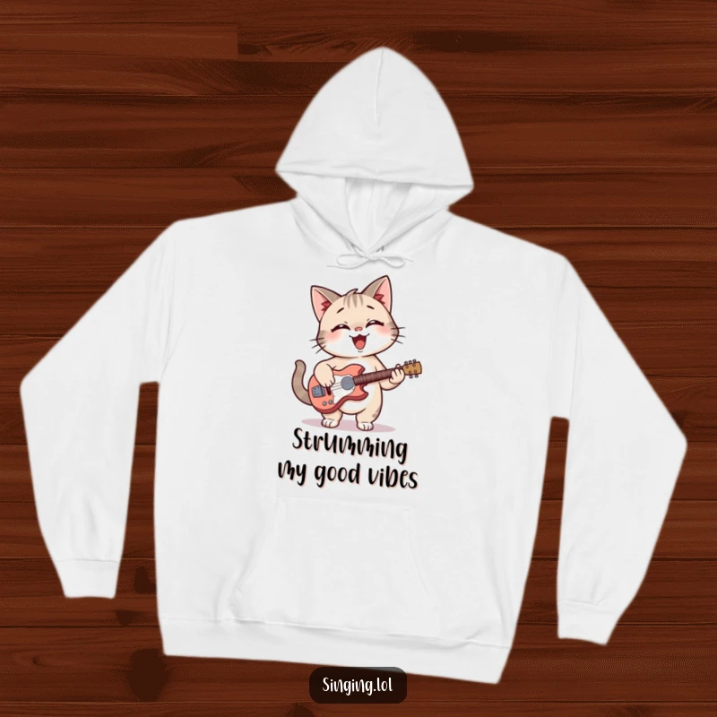 Funny cat giggling with a guitar, featured on a soft hoodie, ideal for casual wear.