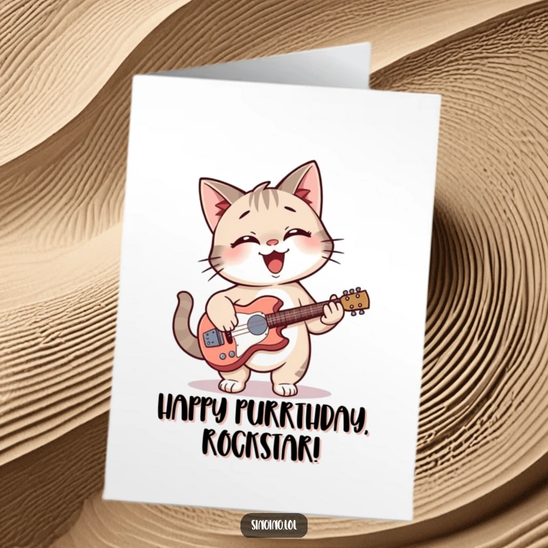 Funny Free Printable Birthday Card: Giggling cat smiles while strumming a tiny guitar, wishing you a rockin birthday.